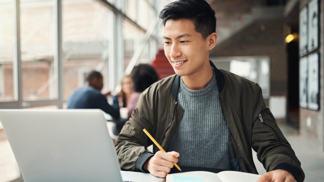 Student studying on laptop on college campus